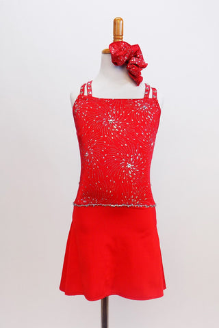 Red camisole style leotard dress has silver firework motif with crystal centers & straps that criss-cross around crystal ring on back. Has matching hair piece. Front