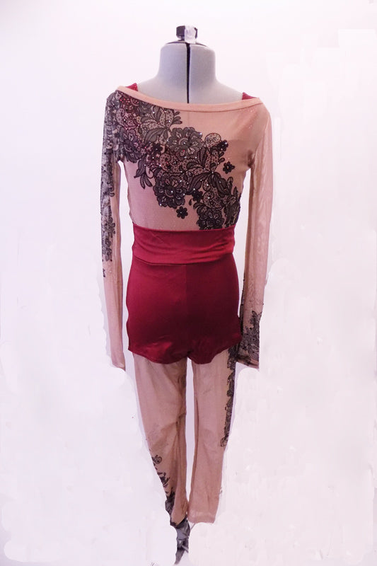 Printed nude mesh full unitard has a black lace pattern in the fabric that cascades at an angle across the torso both front and back. The pattern continues along the long sleeves & legs accented with many scattered crystals. High waisted maroon shorts sit over the unitard and a maroon bra beneath. Front