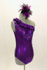 Purple metallic one-shoulder leotard has ruffle accent with crystals. Torso has sequined braiding & large jeweled applique. Comes with feathered hair accessory. Right side
