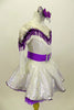 Silver dress has long sleeves and nude mesh upper. The bust-line is decorated with silver sequined, purple and white fringe. The dress has a wide purple belt with matching purple petticoat. Costume comes with silver and purple hair accessory. Right side