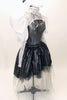Charcoal leotard with open sides & back, has high collar, lace shrug with pleated satin pouf sleeves. Skirt is iridescent black high-low overlay on black & grey tulle. Comes with large white hair accessory. Right side