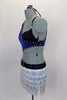 Asymmetrical blue sequined top with black bra is lined with crystals & is connected at the side by a crystal ring. Bottom is an attached white fringed skirt with crystal buckle accent. Has matching hair accessory. Left side