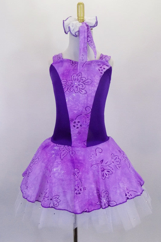 Lavender tutu dress has purple floral print skirt, front center & shoulders, with dark purple sides & back. There is a pleated white 3-layer tutu below skirt. Comes with matching hair accessory. Front
