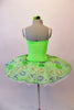 Delicate pale apple green tutu has a white pleated six-layer platter with the attached bodice and overlay. The sparkly green faux sweetheart cut is lined with crystals over a white camisole-style bodice. The sheer sequined lace overlay creates a really pretty soft look. Comes with a green floral hair accessory. Back