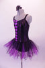 Black and purple-pink camisole leotard dress has a diamond pattern on the right side and pin-stripes on the left. The black and purple tulle attached skirt softens the abstract look. Comes with a black floral hair accessory. Side