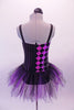 Black and purple-pink camisole leotard dress has a diamond pattern on the right side and pin-stripes on the left. The black and purple tulle attached skirt softens the abstract look. Comes with a black floral hair accessory. Back
