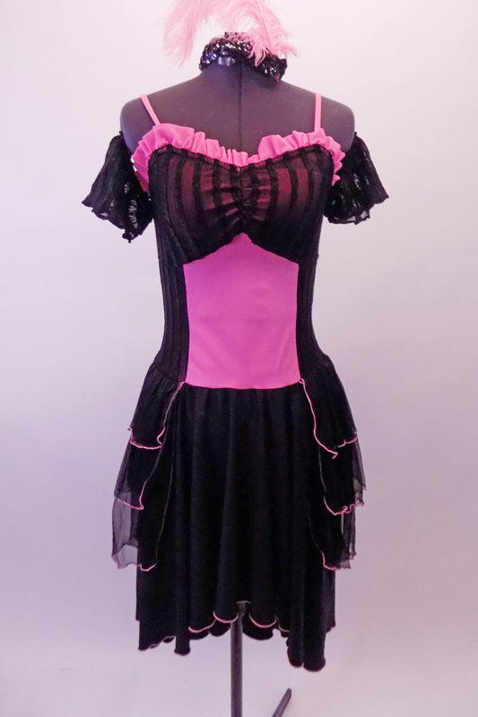 Saloon themed dress has a pink torso overlain by sheer black stripes at bust, sides and back. The knee-length skirt has triple-layered black peplum bustle. Pink ruffles accent the sweetheart neckline. Comes with black sheer striped pull-on sleeves and feathered hair accessory. Front
