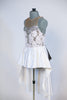 White rose fabric bodice is heavily embossed with large silver appliqués and crystals attached to white high-low skirt with pewter grey long bow at back. Side