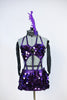 This costume is of jumbo sequined purple fabric.Has bra top with large broach detail, joined to purple panties and a pull-on skirt (gauntlets & head piece). Fromt