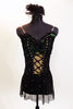 Black merry-widow style mesh dress has lace up corset front with green lace accent. Costume is covered with  crystals & has long black gloves & head piece. Front