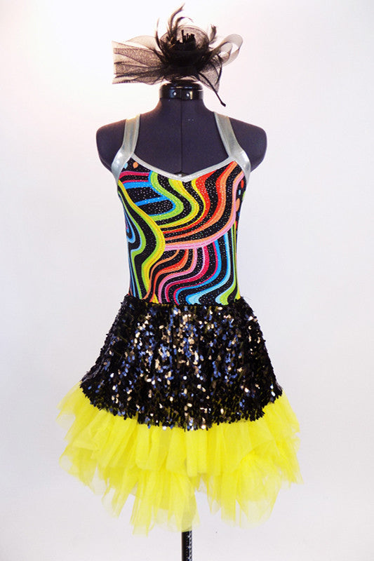 Rainbow swirled patterned leotard with yellow bottom and silver straps, has an attached skirt of ruffled, layered yellow tulle with a black sequined overlay. Front