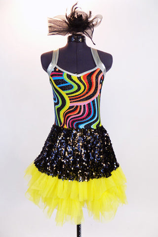 Rainbow swirled patterned leotard with yellow bottom and silver straps, has an attached skirt of ruffled, layered yellow tulle with a black sequined overlay. Front