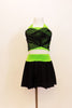 Neon green halter half-top has front cross over black mesh accent. It comes with a black skirt that has attached bottom and matching green waistband. Front