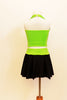Neon green halter half-top has front cross over black mesh accent. It comes with a black skirt that has attached bottom and matching green waistband.  Back