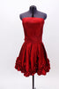 Red strapless taffeta dress has pleated front waist band & smocked back. Bottom of the dress is scalloped with rosettes.Has wide sash that  ties at the back. Front