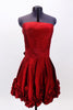 Red strapless taffeta dress has pleated front waist band & smocked back. Bottom of the dress is scalloped with rosettes.Has wide sash that  ties at the back. Front zoom