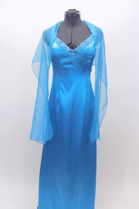 Floor length satin turquoise gown has jeweled trim at bust. The straps from the shoulder and bottom of bust line cross over at back. Has long chiffon train. Front with shawl