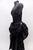 Black ruched back, long sateen dress has short draped front for easy movement with crystal broach accents . Layered bustle effect carries through to  back. Side