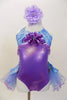 Lavender  and aqua leotard has tulle bustle skirt. Bodice is accented with lavender beads &  large purple sequined flower. Has is a large flower hair accessory Front