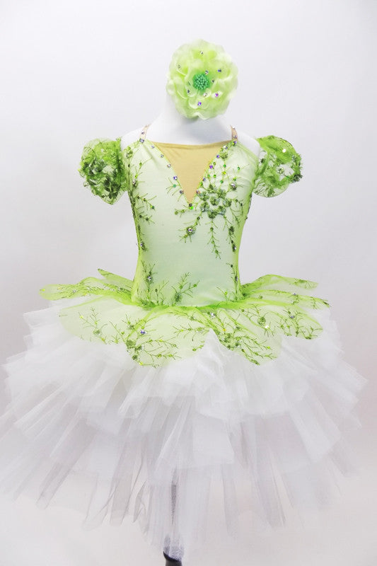 Green embroidered beaded lace tutu bodice has attached lace overlay which sits on top of white tutu. Comes with lace arm poufs and green floral hair accessory. Front
