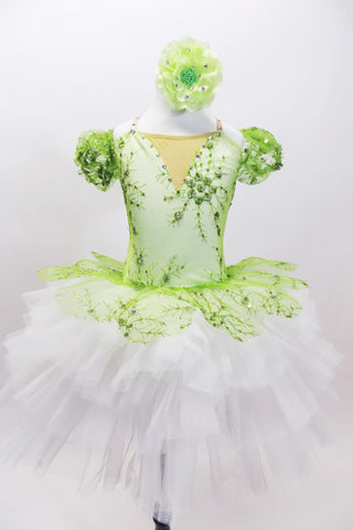 Green embroidered beaded lace tutu bodice has attached lace overlay which sits on top of white tutu. Comes with lace arm poufs and green floral hair accessory. Front