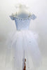 White lace leotard has attached crystal covered tutu skirt  & drop shoulder sleeves. Neckline has bridal lace with beads & pearls. Has hair accessory with veil. Back