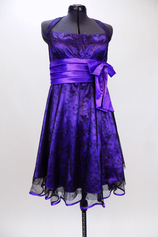 Purple halter  A-line knee length dress has black lace overlay & purple satin piping on petticoat. Has wide pleated  waistband with large satin bow under bust. Front