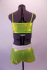 Lime green metallic two-piece costume is a camisole style tank top with princess cut. The matching bootie shorts has an attached white belt with silver oval buckle accent. Comes with a floral hair accessory. Back