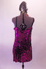Magenta sequined slip dress with black wide shoulder straps is accompanied by a sequin applique and feather hair accessory. Back
