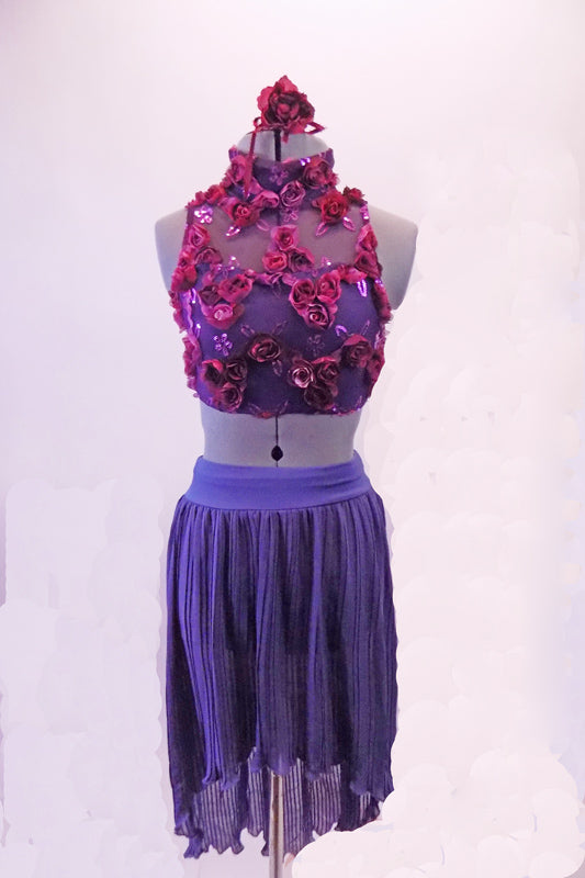 Periwinkle finely pleated chiffon, knee-length high-low skirt has a wide waistband. The high neck half-top has a periwinkle base with a purple sheer that is adorned with sild roses in shades of pinks, purples and deep berry. Comes with deep berry coloured floral hair accessory. Front
