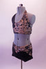 Black 2-piece costume with a bra top and short has a unique overlay along the neck, left bust, hip and waist that resembles pebbles and river rock adorned with crystals. The pattern is shades of browns and greys with a 3-D texture. Comes with a hair accessory. Left side