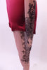 Printed nude mesh full unitard has a black lace pattern in the fabric that cascades at an angle across the torso both front and back. The pattern continues along the long sleeves & legs accented with many scattered crystals. High waisted maroon shorts sit over the unitard and a maroon bra beneath. Leg zoomed