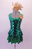 Green sequined peplum dress has shimmery green skirt below the peplum that matched the banding of the halter collar and large bow at the back of the neck. The removable gold accent flower compliments the large gold fascinator headband accessory. Front