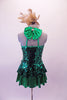 Green sequined peplum dress has shimmery green skirt below the peplum that matched the banding of the halter collar and large bow at the back of the neck. The removable gold accent flower compliments the large gold fascinator headband accessory. Back