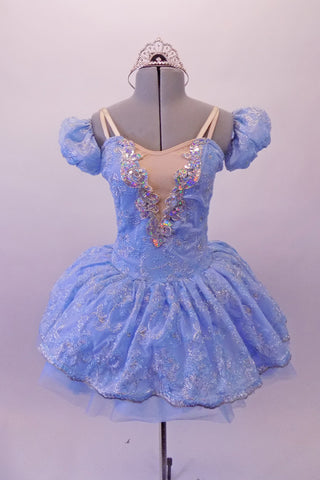 Cinderella-blue tutu dress has a sheer silver floral lace overlay. A wide iridescent sequined applique accents the V-insert nude front. The sweetheart bust had double v-straps that merge to a single adjustable strap at back. Comes with a crystal tiara. Front
