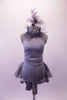 Halter style silver-grey silver unitard with ruched waist has feather accents lining the collar. The wide T-back give the costume a unique flare & good support. Attached is a high low-style layered bustle skirt in canvas-type cotton adorned with small crystals throughout. Comes with a large crystal-accented hairband. Front