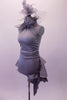 Halter style silver-grey silver unitard with ruched waist has feather accents lining the collar. The wide T-back give the costume a unique flare & good support. Attached is a high low-style layered bustle skirt in canvas-type cotton adorned with small crystals throughout. Comes with a large crystal-accented hairband. Left side