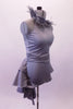 Halter style silver-grey silver unitard with ruched waist has feather accents lining the collar. The wide T-back give the costume a unique flare & good support. Attached is a high low-style layered bustle skirt in canvas-type cotton adorned with small crystals throughout. Comes with a large crystal-accented hairband. Right side