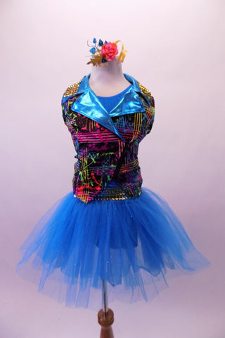 Colourful costume has a turquoise tulle skirt with rainbow sequin waistband, attached to a turquoise short unitard base. The brightly coloured graffiti-style vest has shiny blue lapels with wide rainbow sequin accent. Comes with matching gauntlets and hair accessory. 