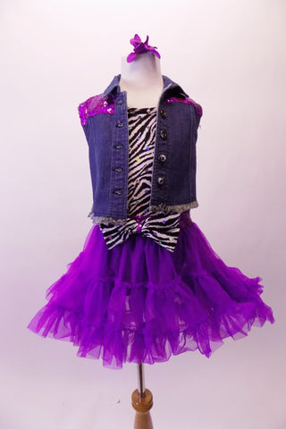 Zebra print short unitard with black bottom comes with a purple ruffled pull-on layer skirt with sequined waistband and large zebra bow accent at the front. A denim vest with purple sequined back accompanies the outfit. Comes with zebra stirrup socks, flower hair accessory and purple sequined gauntlets. Front