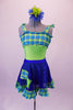 Fun lime green-based leotard has blue-green plaid blouson-style bust area that ties at the shoulders. The matching blue sequined pull-on skirt has plaid ruffle edge and faux decorator pockets. Comes with a floral hair accessory. Front