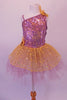Gold and lavender tutu dress has a single shoulder with a single strap. The bodice is a marble of lavender and gold covered in sequins. The lavender tulle, knee-length skirt, has a gold sequined overlay. Gold sequined flowers accent the left shoulder and right hip. Front