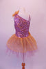 Gold and lavender tutu dress has a single shoulder with a single strap. The bodice is a marble of lavender and gold covered in sequins. The lavender tulle, knee-length skirt, has a gold sequined overlay. Gold sequined flowers accent the left shoulder and right hip. Back