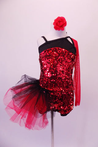 Red sequined short unitard has a black bust area angle & strapped in a unique angle with single red mesh long sleeve. The deep open back has three angled straps with a large sequined red and black floral accent. A large red and black tulle side pouffe accents the right hip. Comes with a red floral hair accessory. Front