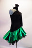 Dress has a black torso with a single shoulder and long left pouffe sleeve, attached to a neckband collar. The entire torso is covered with SS20 black crystals and is angled down towards the right hip. The emerald satin skirt had layered black ruffled petticoat for added volume. Comes with a hair accessory. Side