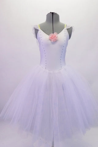 White romantic tutu dress has a princess-cut torso which is lined along the seams with crystals. A pretty pink floral accent adorns the front. Comes with floral hair accessory. Front