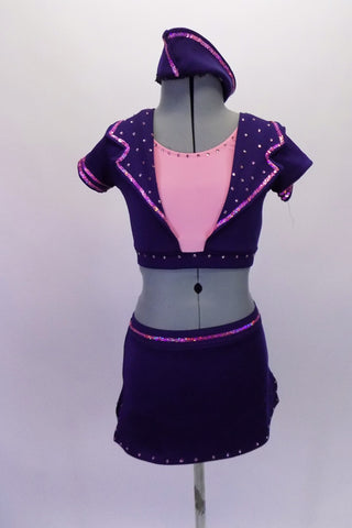 Flight attendant themed 2-piece costume is navy with pink accents, crystalled lapel collar with short sleeves. The matching short skirt with built-in brief ahs small side slits. Comes with matching fight hat. Front