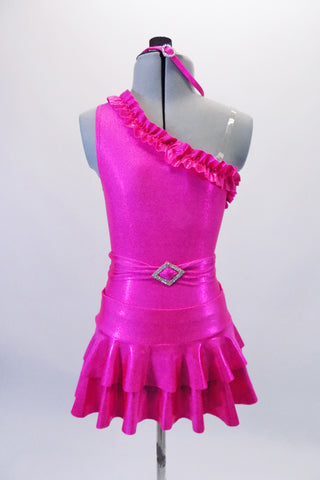 Bright fuchsia one shoulder leotard with a ruffled neckline is accompanied by a double layer ruffled skirt and matching shorts. Comes with a pull-on belt with crystal buckle accent and matching headband. Front