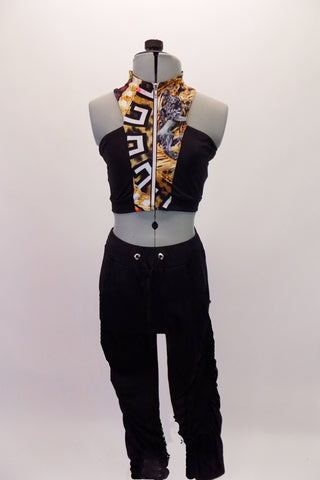 Two-piece costume has black lycra, Capri length, drawstring pants that gather up the sides. The pants are accompanied by a high collared, racer-back style crop top. The top has a front and back centre with animal print, zipper front and open shoulders. Front