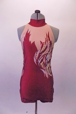 High halter collared, open-backed short unitard has a burgundy-rust base on nude with a flame flare on the left bust with hints of pink and pale blue and accented with crystals. Front